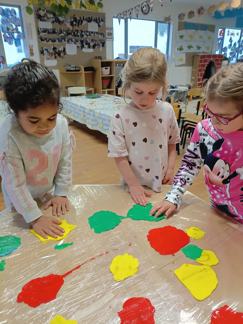 Children exploring colourful paint printing at Highfield Haven